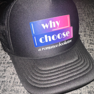 Photo of a Black hat with mesh sides and a purple and pink logo for Why Choose: A Romance Bookstore